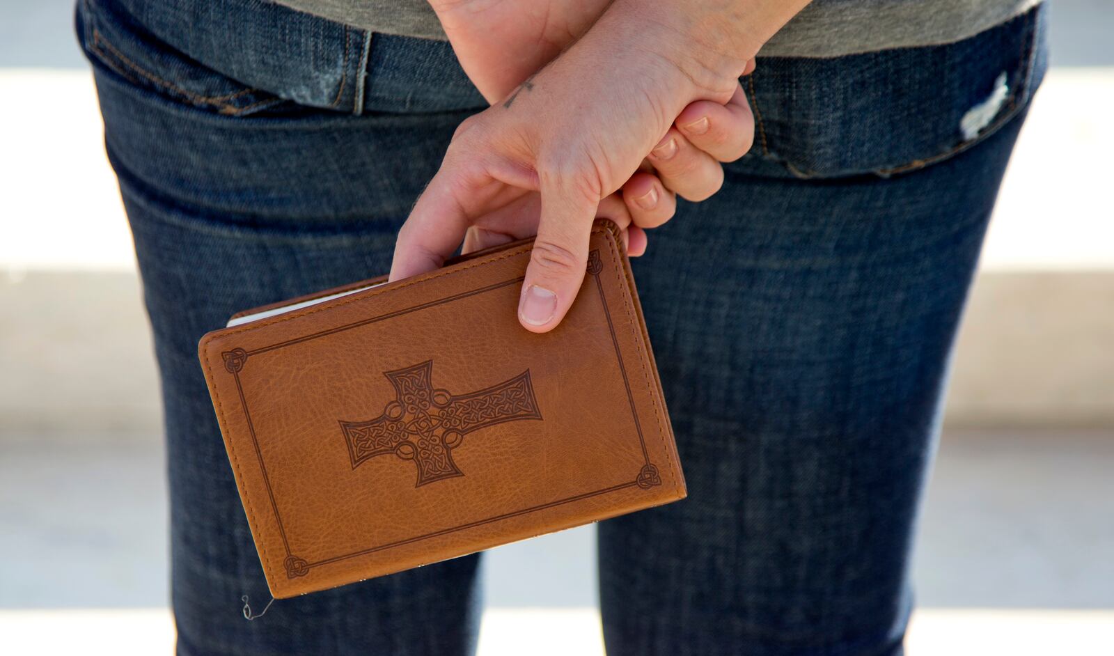 A woman holds a Bible as she prays on the front steps of the Supreme Court in Washington, Monday, Oct. 1, 2012.