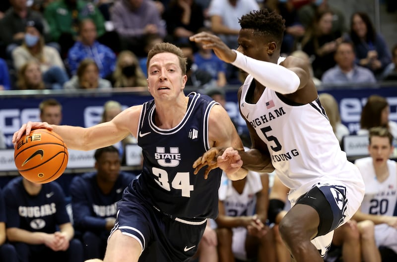 Utah State’s Justin Bean (34) drives on BYU’s Gideon George (5) during a game in Provo at the Marriott Center on Wednesday, Dec. 8, 2021.