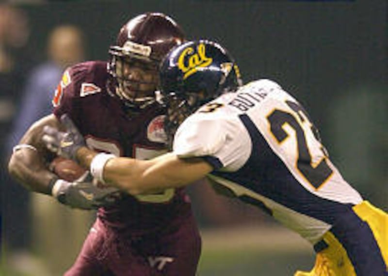 Virginia Tech's Kevin Jones, left, protects the ball from California's Ryan Gutierrez (23) during the Insight Bowl Friday in Phoenix.