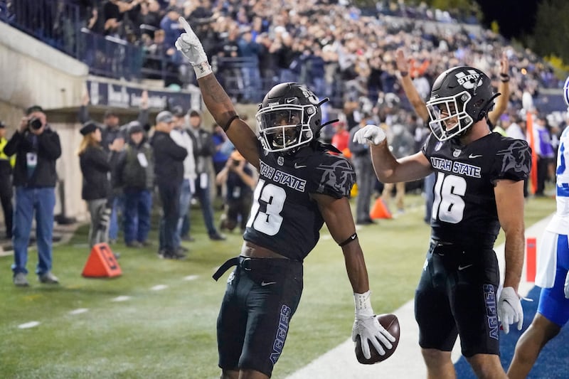 Utah State wide receiver Deven Thompkins (13) celebrates after scoring against BYU