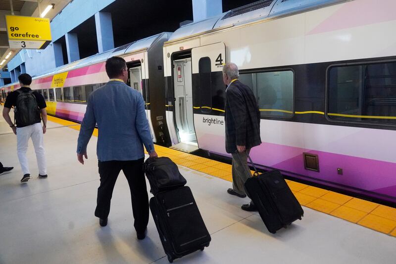 Passengers walk to board the first train service from Miami to Orlando on Sept. 22, 2023, in Miami.