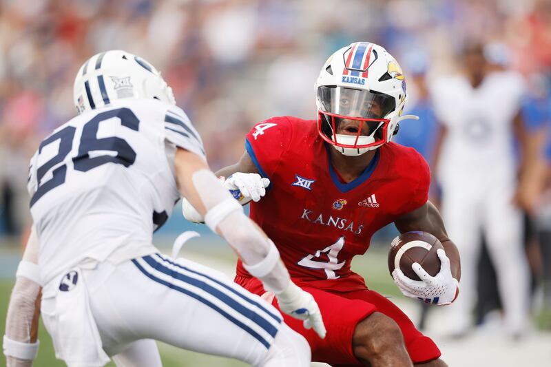 Kansas running back Devin Neal (4) rushes for a first down as BYU safety Ethan Slade (26) defends during game on Saturday, Sept. 23, 2023 in Lawrence, Kan.