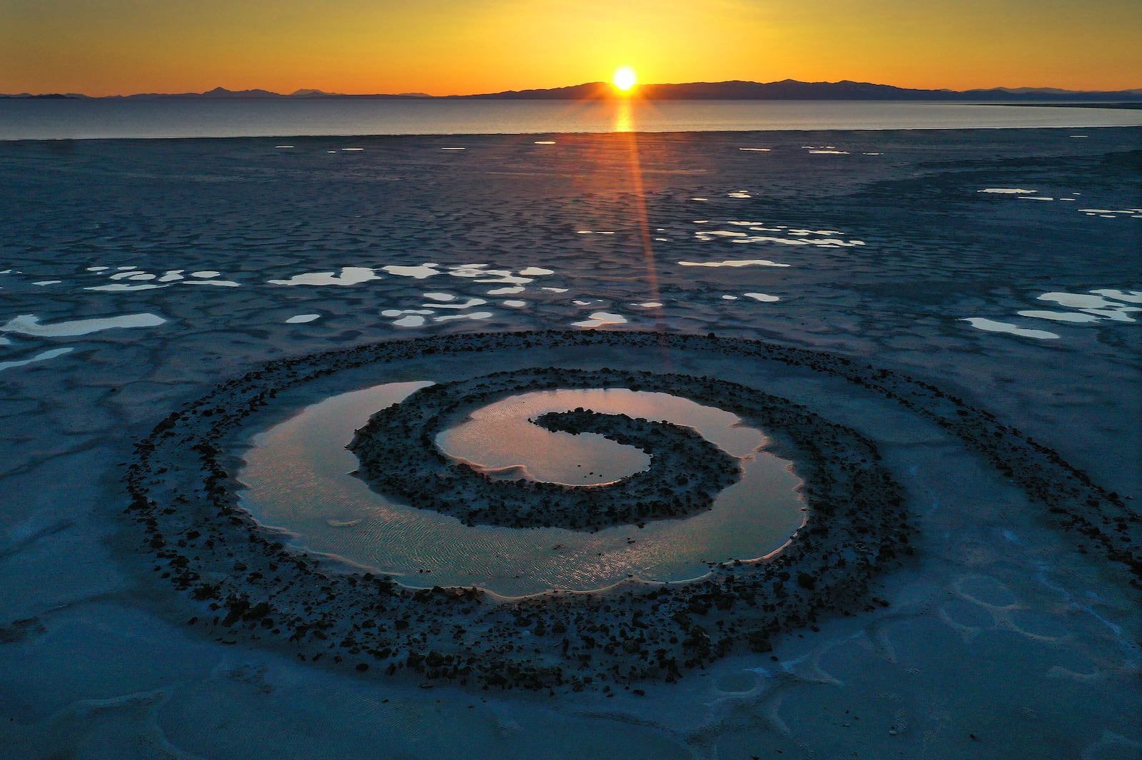 The sun sets on the Spiral Jetty on the Great Salt Lake on Thursday, March 16, 2023.
