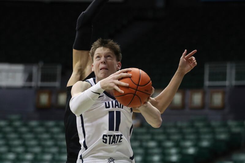 Utah State guard Max Shulga goes to the basket in front of SMU forward Samuell Williamson during the first half of an NCAA college basketball game Friday, Dec. 23, 2022, in Honolulu. (AP Photo/Marco Garcia)
