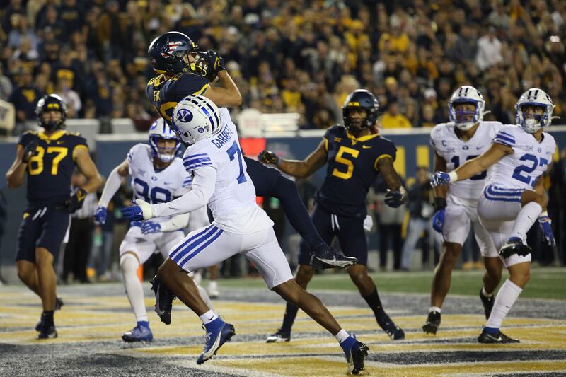 West Virginia’s Preston Fox, top center, catches a touchdown over BYU’s Kamden Garrett.