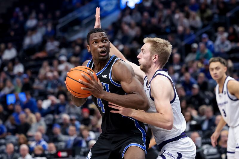 BYU Cougars forward Atiki Ally Atiki (wearing black) drives against Westminster Griffins forward/center Trey Farrer (wearing white).