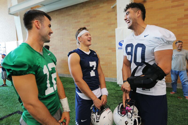 BYU quarterback Tanner Mangum, running back/quarterback Beau Hoge and Corbin Kaufusi talk after a walkthrough in their indoor practice facility in Provo on Friday, Aug. 10, 2018.