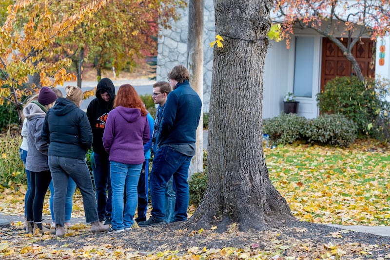 People gather to pray outside of the Pi Beta Phi sorority house at the University of Idaho.