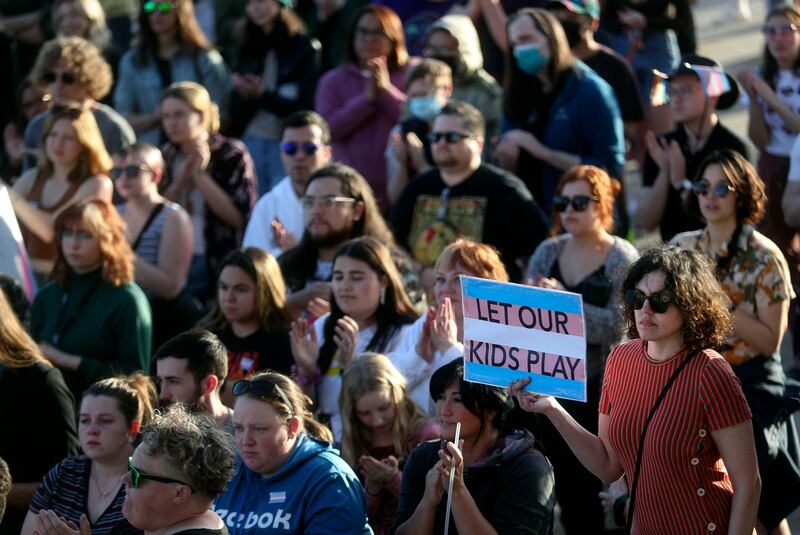 Carinne James holds a “Let our kids play” sign during a rally to support transgender youths at the Capitol in Salt Lake City.