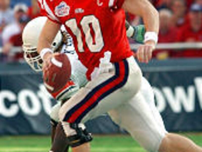 Mississippi quarterback Eli Manning scrambles out of the pocket in the third quarter during the Cotton Bowl against Oklahoma State.