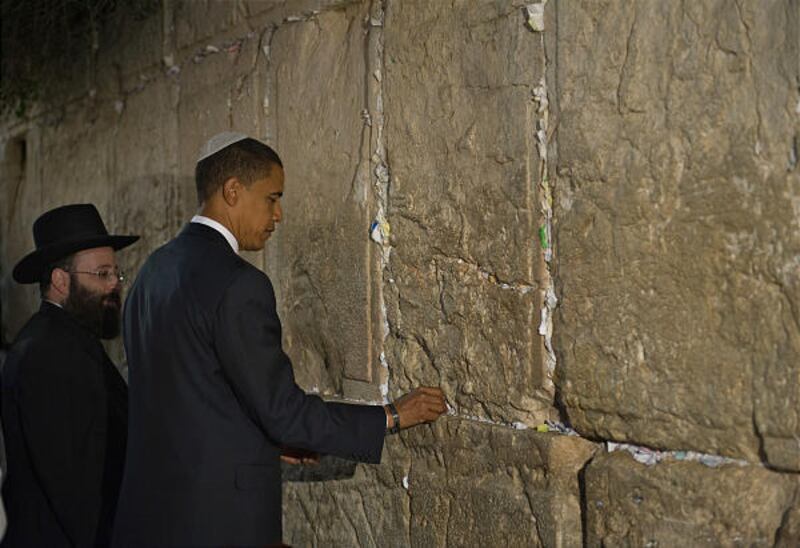Rabbi Shmuel Rabinovich stands next to Barack Obama as the presidential candidate places a hand-written prayer inside a crevice in the Western Wall.