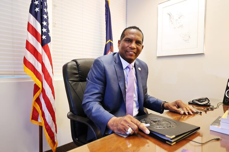 Rep. Burgess Owens smiles sitting at his desk at his West Jordan offices.