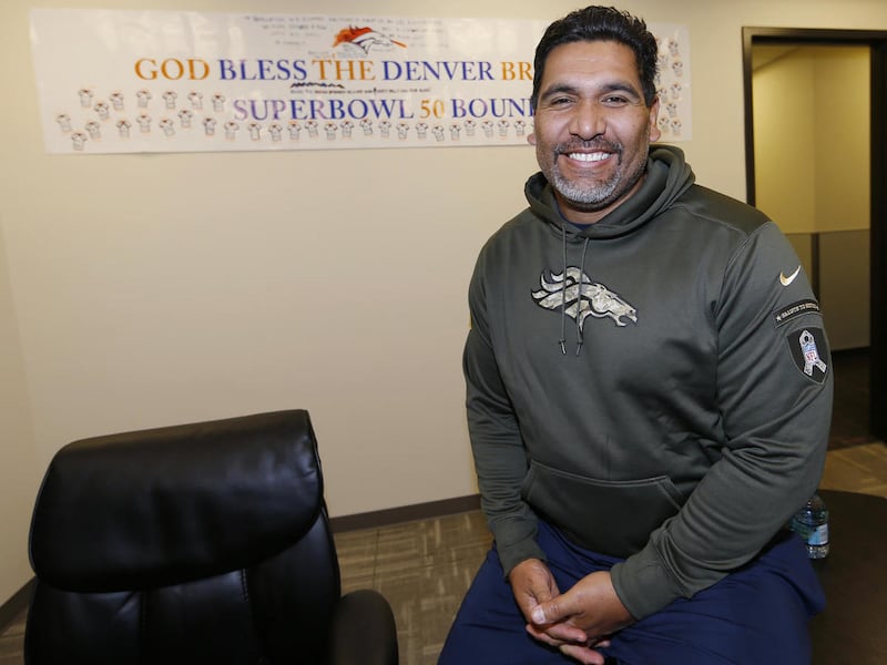 In this Wednesday, Dec. 16, 2015 photo, Denver Broncos team chaplain Luther Elliss poses for a photo in his office in the team's headquarters in Englewood, Colo. Elliss, once the highest-paid defensive tackle in the NFL before losing it all and going bank