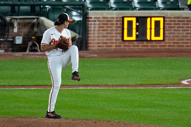The pitch clock is visible as Baltimore Orioles starting pitcher Dean Kremer winds up against the Boston Red Sox in Baltimore, Md.