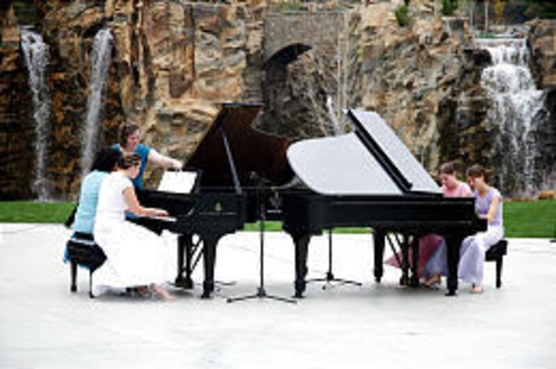 A piano quartet made up of Sienna White, left, teacher Kalotini Latu, Laurie Haupt and Haley Hansen performs recently at Thanksgiving Point's Tulip Festival, as Patricia Jarrett, standing, turns pages. Rain made for a challenging concert.