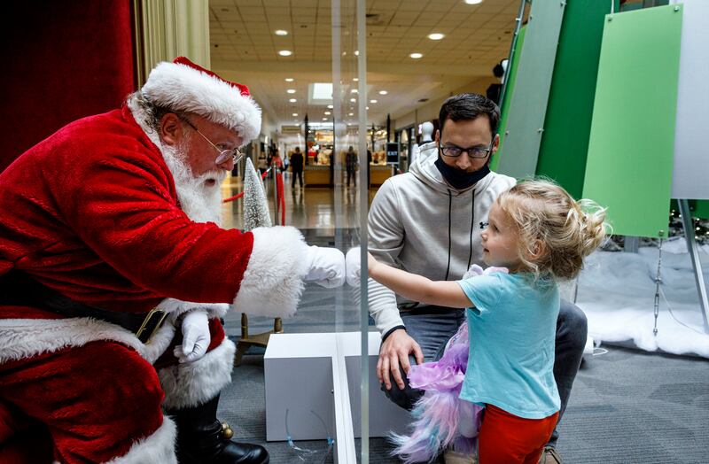 Tyler Rapsey with daughter Isabelle visits with Santa Claus, with safety protocols in place, at Capital City Mall in Lower Allen Township, Pa., on Wednesday, Nov. 11, 2020.