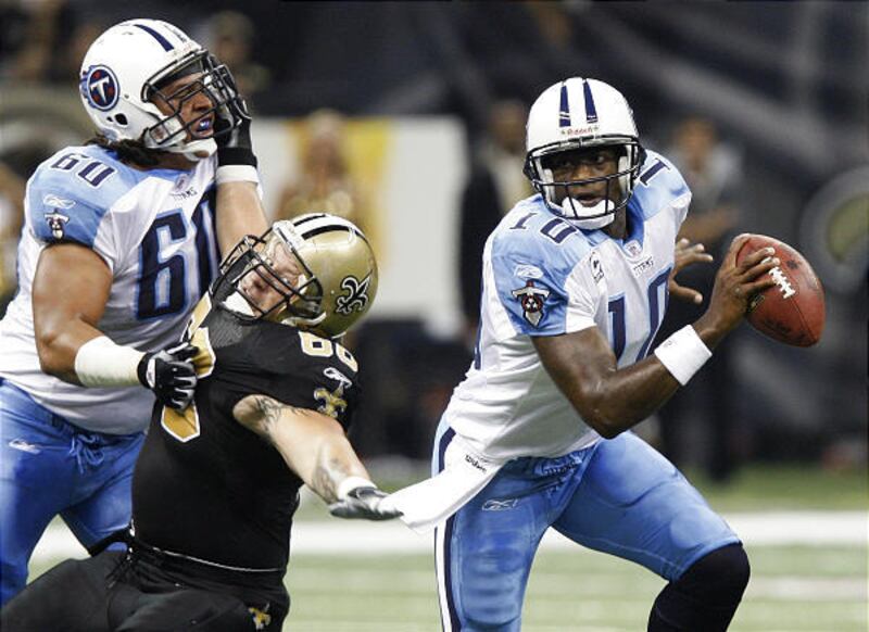 Tennessee quarterback Vince Young (10) scrambles away from New Orleans defender Brian Young (66) as Titans lineman Jacob Bell (60) blocks during the Titans' win Monday in New Orleans.