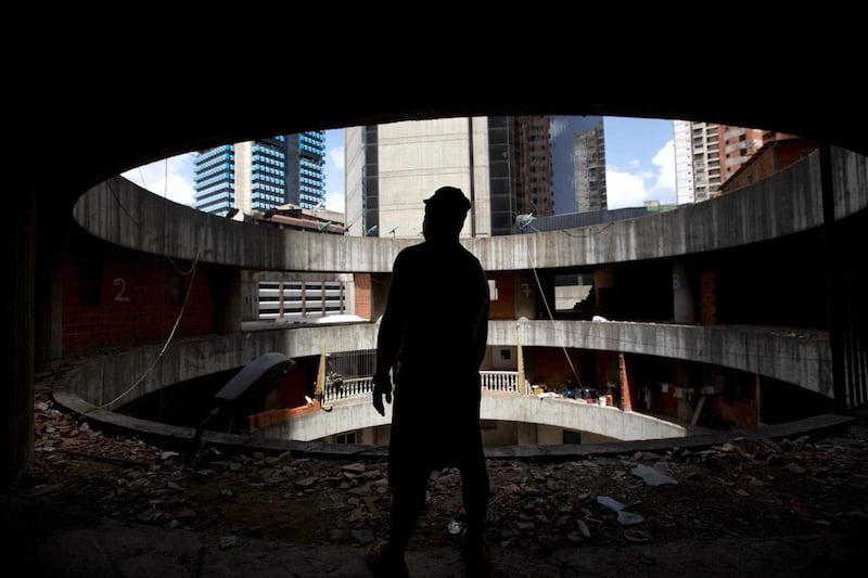 A resident waits for transportation to a new home after being evicted from the world’s tallest slum, the Tower of David, a half-built skyscraper that was abandoned in the 1990s and was transformed by squatters into a vertical ghetto, in Caracas, Venezuela