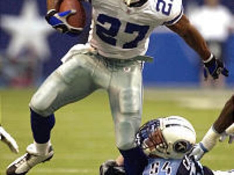 Dallas running back Eddie George (27) is grabbed by Tennessee's Rocky Calmus (54). George had only 3 yards against his old team.