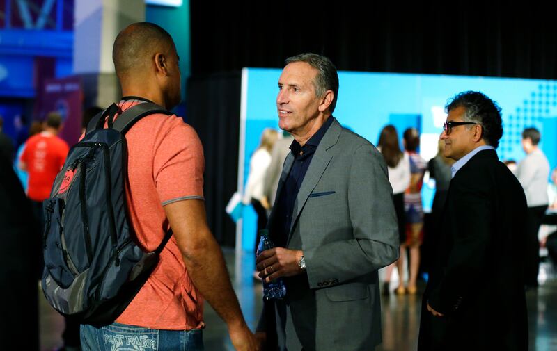 In this May 5, 2016, file photo, Howard Schultz, center, CEO of Starbucks Corp., talks with an an attendee at a job fair in Seattle sponsored by the 100,000 Opportunities Initiative. For someone who has given about $150,000 to Democratic campaigns over th