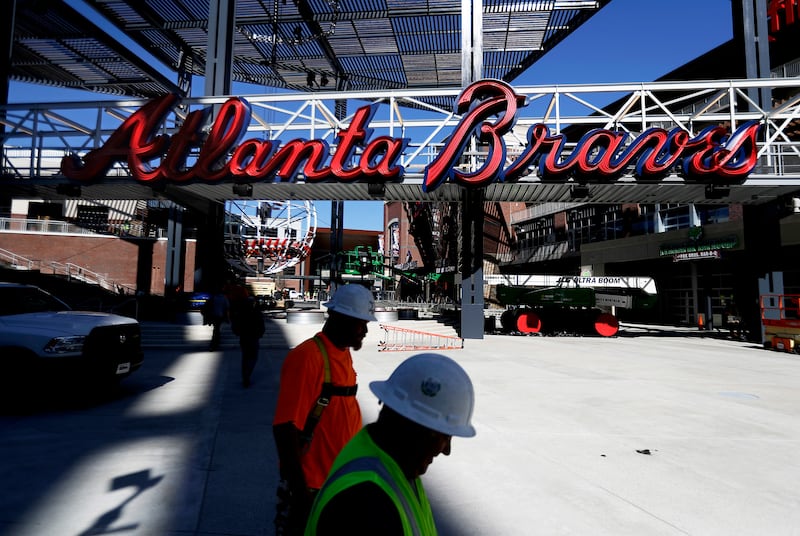 Construction workers walk past a mixed-use area to feature restaurants and retail stores at SunTrust Park, the Atlanta Braves’ new baseball stadium in Atlanta.