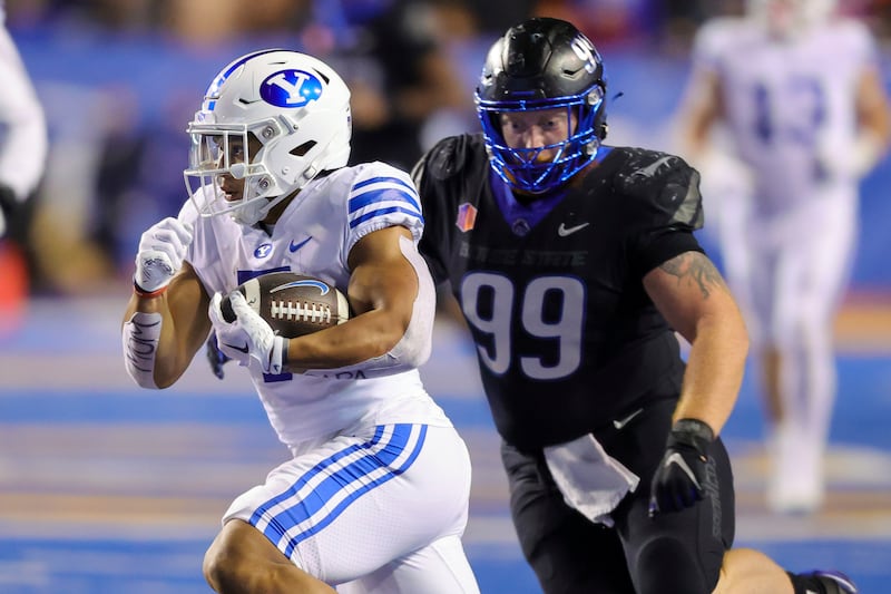 BYU running back Hinckley Ropati, left, runs with the ball in front of Boise State defensive tackle Scott Matlock (99) on a 48-yard touchdown reception.