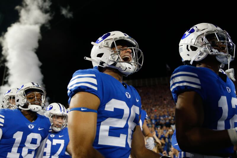 BYU players make their way onto the field ahead of an NCAA college football game against Utah.