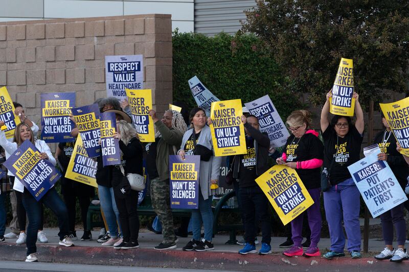Kaiser Permanente workers carry protest signs outside the hospital during a strike in Los Angeles.