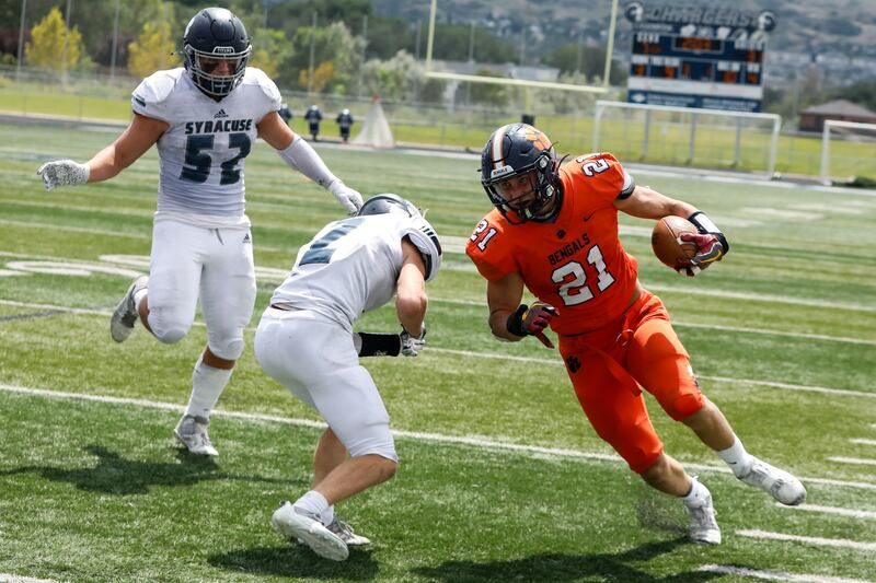 Brighton’s Lander Barton (21) runs through Syracuse’s defense.