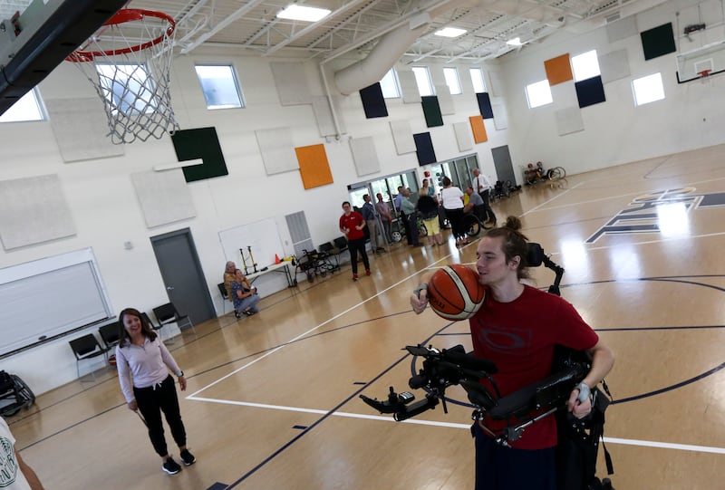 Jack Racicot, right, uses the gym at Neuroworx in Sandy as the Utah Spinal Cord Injury and Brain Injury Rehabilitation Fund advisory committee tours the facility on Thursday, July 11, 2019.
