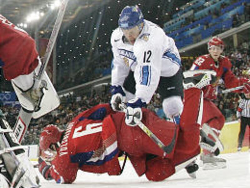 Finland's Olli Jokinen (12) knocks Russia's Anton Volchenkov (6) to the ice during the second period of Friday's Olympic semifinal.