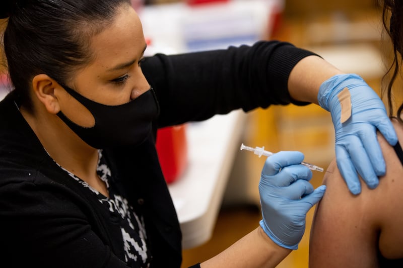 Smith’s pharmacy technician Wendy Flores administers a dose of the Pfizer-BioNTech COVID-19 vaccine during a vaccination event at a church in Salt Lake City on Saturday, March 20, 2021.