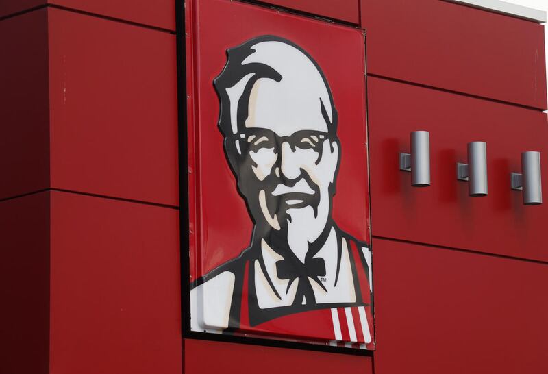 FILE - In this Tuesday, Oct. 9, 2012, file photo, a close-up of a sign with a picture of Colonel Sanders is shown on the wall of a combination Kentucky Fried Chicken, Taco Bell in Doral, Fla. KFC said it will start delivering its buckets of fried chicken