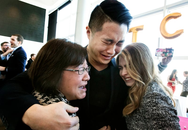 University of Utah medical school student Marcus Chen, center, cries with his mother Ling-Ling Chen and friend Sarah Eckstein after opening a letter of acceptance to the University of Utah's Department of Anesthesiology during Match Day at Rice Eccles Sta