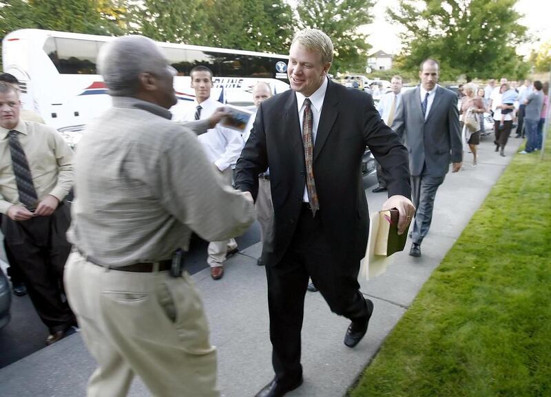 BYU head coach Bronco Mendenhall greets friend Kenneth Jones as members of the BYU football team arrive for a fireside in Seattle on Sept. 5, 2008.
