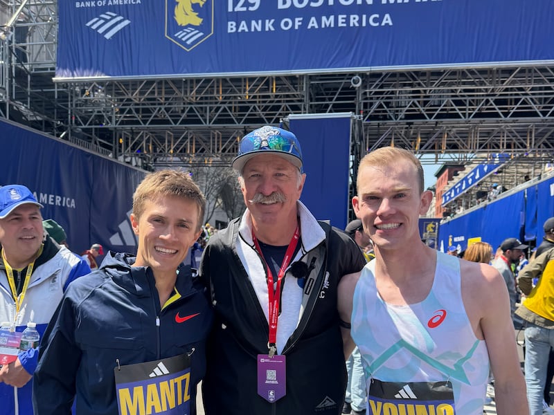 Conner Mantz, left, and Clayton Young, right, pose with coach Ed Eyestone after the Boston Marathon Monday, April 21, 2025.
