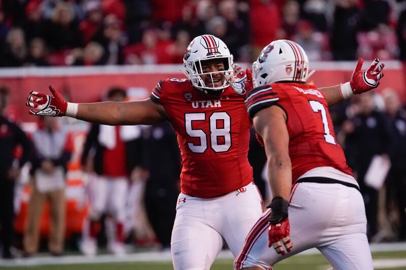 Utah defensive tackle Junior Tafuna, left and Utah defensive end Van Fillinger celebrate.