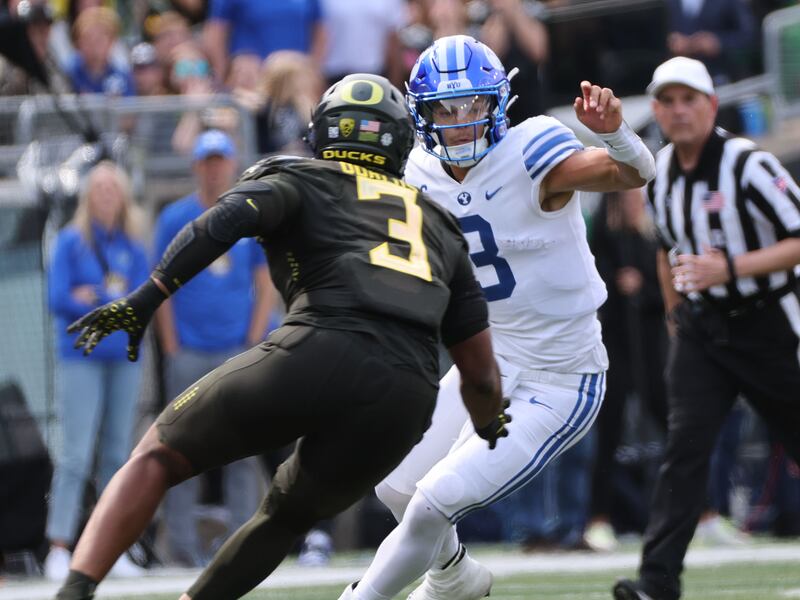 BYU quarterback Jaren Hall (3) runs against Oregon Ducks defensive end Brandon Dorlus (3) in Eugene on Sept. 17, 2022.