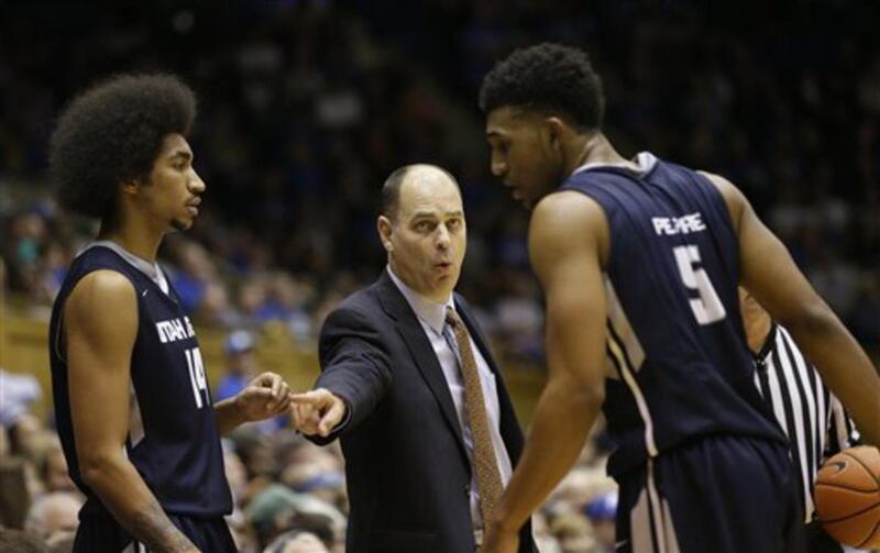 Utah State's Jalen Moore (14) and Julion Pearre (5) speak with coach Tim Duryea during the second half of an NCAA college basketball game in Durham, N.C., Sunday, Nov. 29, 2015. Duke won 85-52.