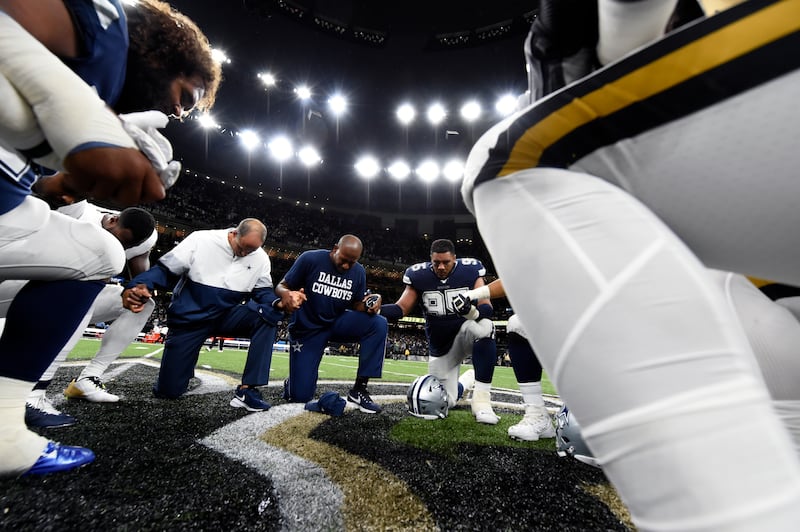 Players and coaches from the New Orleans Saints and Dallas Cowboys pray together on the field after a Sept. 2019 game.