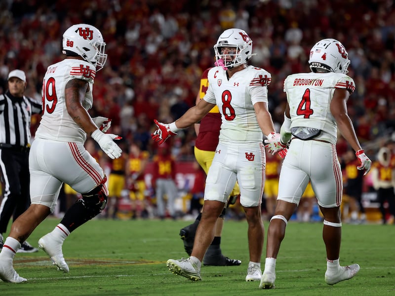 Utah Utes safety Cole Bishop (8) is congratulated by teammates after a play in the game against the USC Trojans.