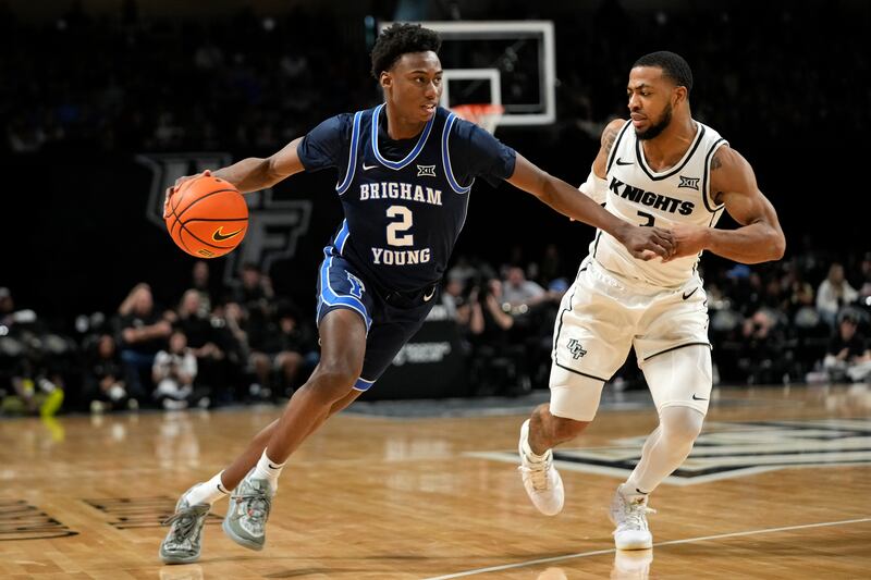 BYU guard Jaxson Robinson (2) drives past Central Florida guard Darius Johnson, right, during the second half of an NCAA college basketball game, Saturday, Jan. 13, 2024, in Orlando, Fla.