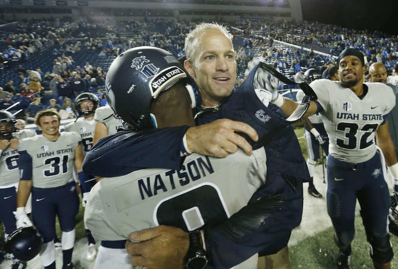 Utah State Aggies head coach Matt Wells hugs Utah State Aggies wide receiver JoJo Natson (9) in Provo Saturday, Oct. 4, 2014.
