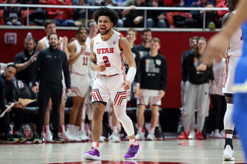 Utah Utes guard Mike Saunders Jr. (wearing white) celebrates