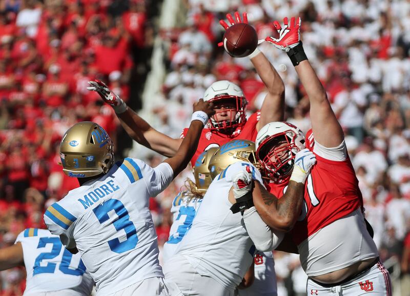 Utah Utes linebacker Lander Barton (20) and Utah Utes defensive tackle Keanu Tanuvasa (57) try to block a pass by UCLA Bruins quarterback Dante Moore (3).