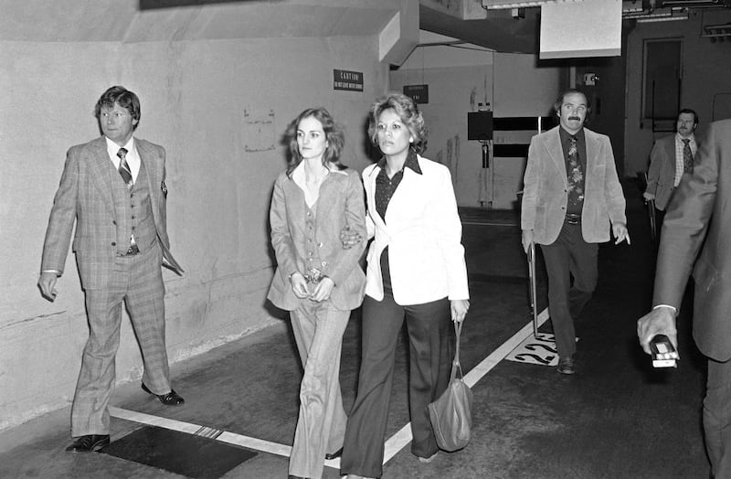 Patty Hearst is escorted to an elevator by a deputy U.S. Marshal in the basement of San Francisco’s Federal Building, April 12, 1976.
