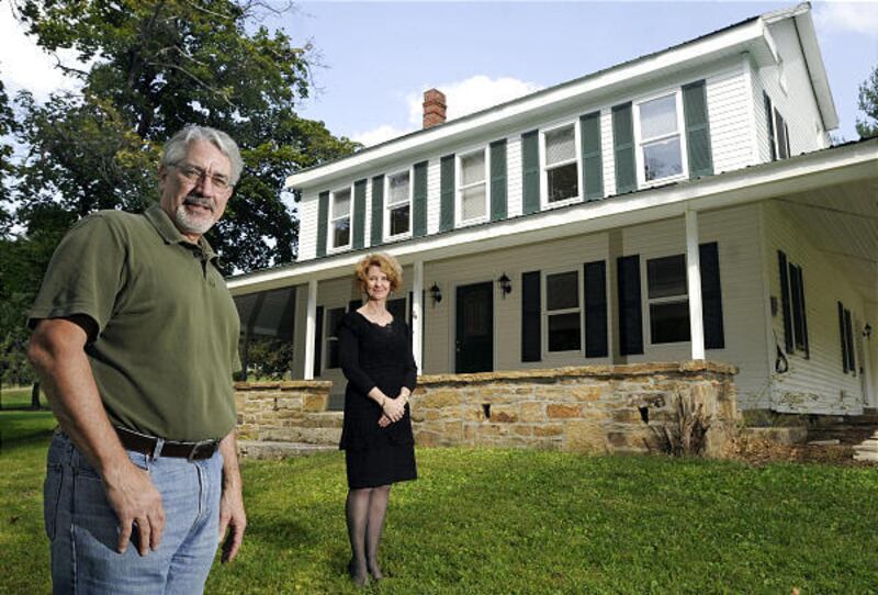 Dennis Weaver stands outside the home he won from Karen Crawford, right. Because of high taxes, Weaver is trying to sell the house.