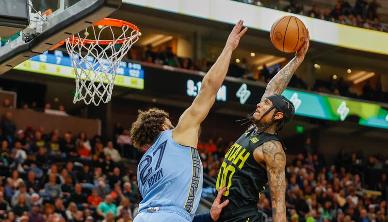 The Utah Jazz’s Jordan Clarkson goes for a dunk while the Memphis Grizzlies’ David Roddy blocks him during an NBA game in Salt Lake City on Monday, Oct. 31, 2022.
