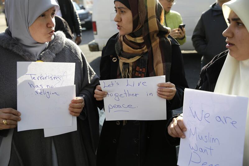Amina Ismail, left, Fatima Amaziane, center, and Dalia Abdallah hold signs during a news conference in the Queens borough of New York, Thursday, Dec. 10, 2015. The news conference was called to express opposition to hate crimes and rhetoric, particularly