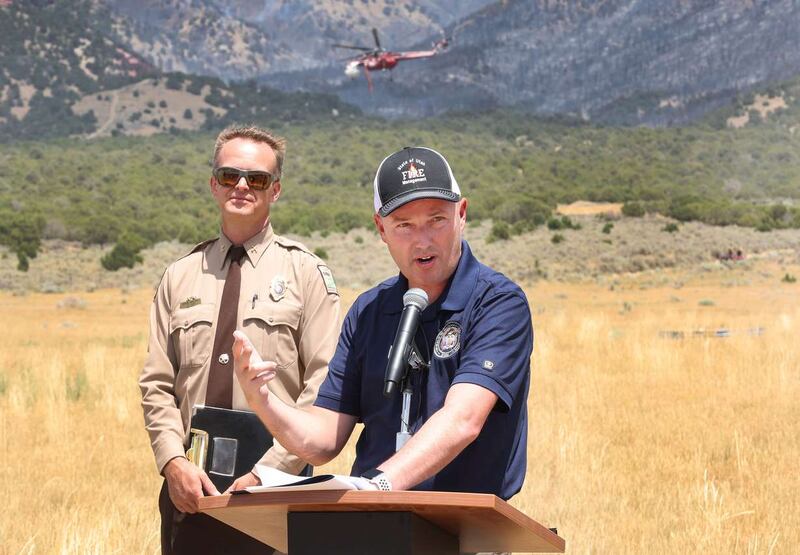 Daniel Walton, Tooele County fire warden, listens to Gov. Spencer Cox near the Jacob City Fire in Tooele County, on July 11, 2022.